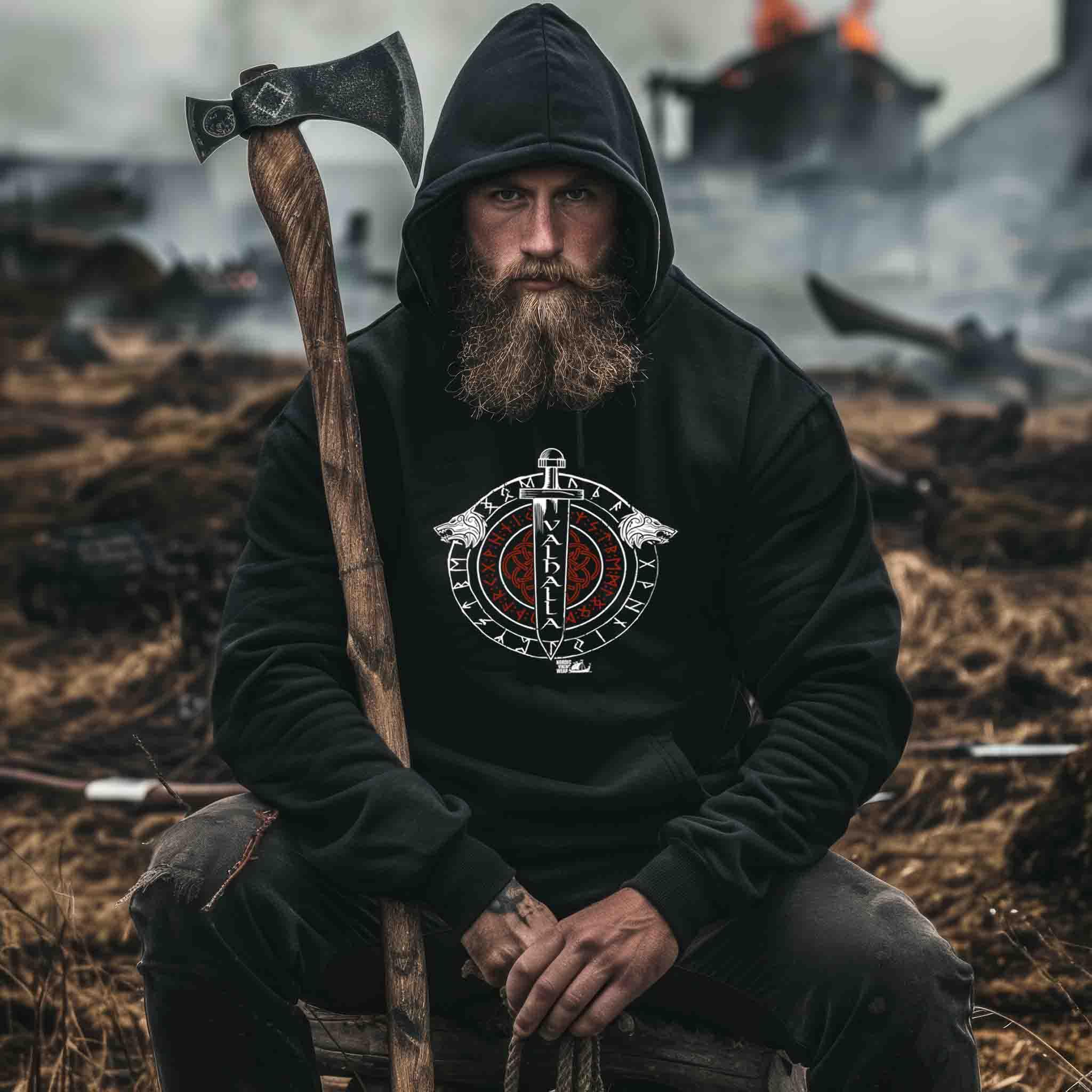 Bärtiger Mann im Wikinger Hoodie mit Axt, nordische Kleidung, mystische Kulisse, Nordic Viking Wear